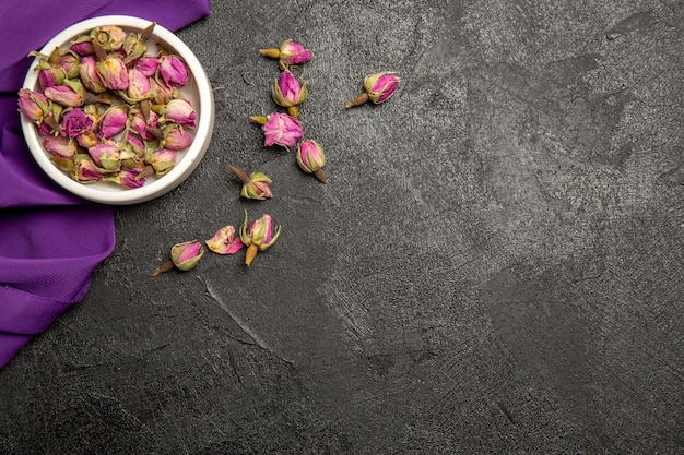 Top view of little purple flowers with purple tissue on grey