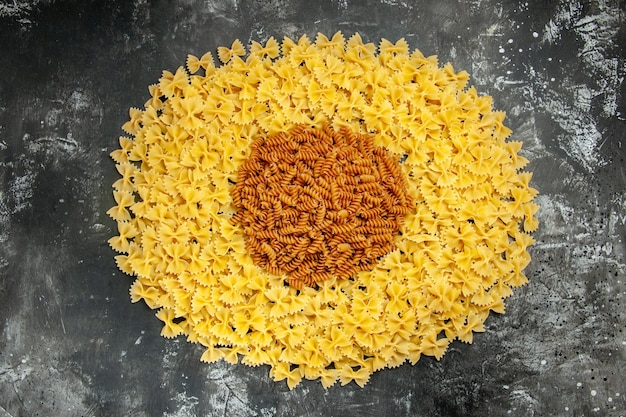 Top view little raw pasta on grey background