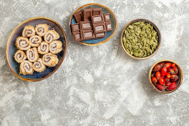 Free photo top view little roll candies with chocolate bars on white background