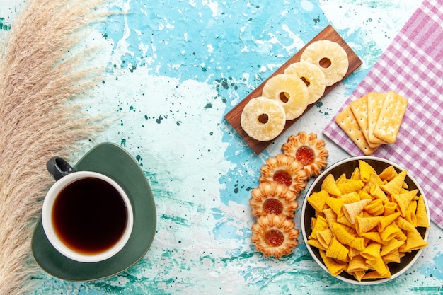 Free photo top view little spicy chips with crackers dried pineapple rings and cookies on the blue background chips snack color crisp calorie