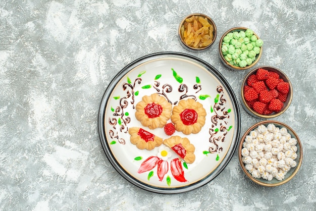 Top view of little sugar cookies with candies on white