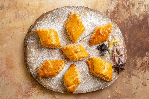 Free photo top view of little sweet pastries for tea on light desk