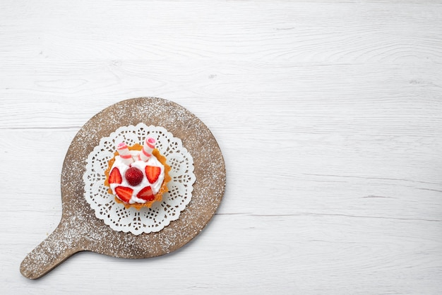 Free photo top view little yummy cake with cream and sliced strawberries on the white background cake berry sweet sugar bake