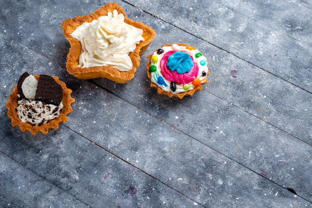 Top view little yummy cakes with cream on the light background candy sweet cake photo