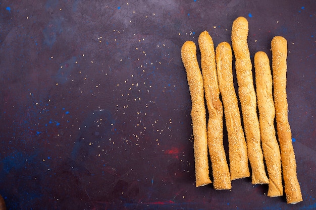 Top view of long bun bread long formed baked bun on the dark surface