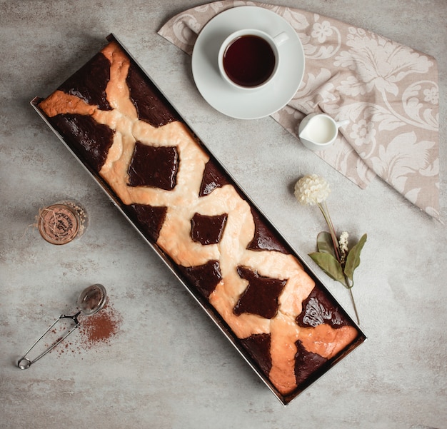 Top view of long chocolate pie served with tea