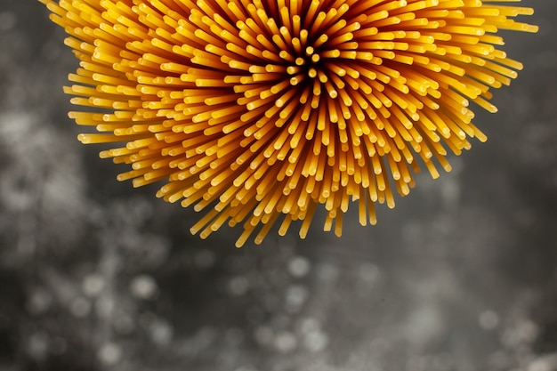 Top view long italian pasta raw on dark-grey background