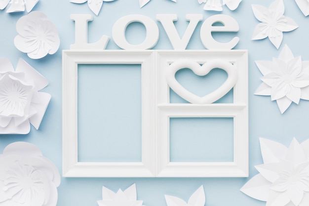 Free photo top view love frame with paper flowers