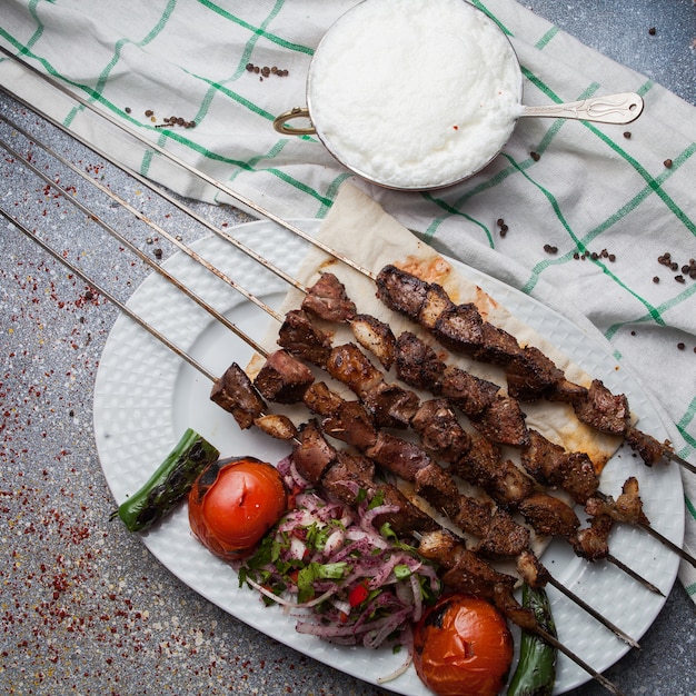 Free photo top view lule kebab with tomato and onion and ayran