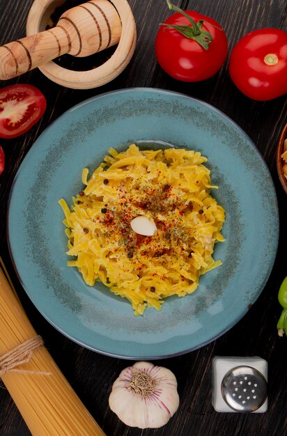 Top view of macaroni pasta in plate with tomatoes