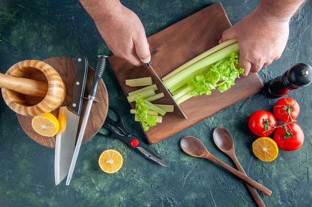 Free Photo top view male cook cutting celery on dark table salad diet meal color photo food health