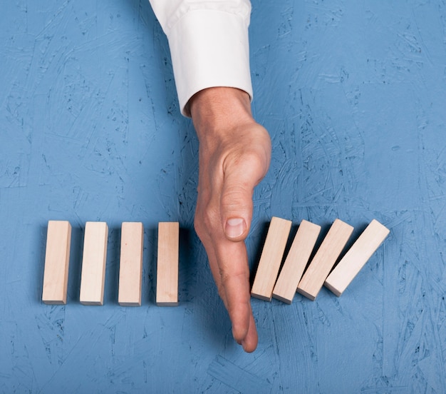 Free photo top view man blocking pieces of wood from falling