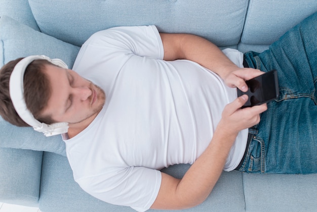 Top view man listening to music on headphones