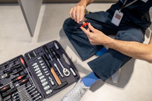 Top view of man sitting on floor with tap