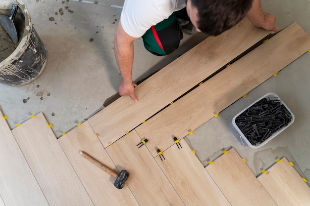 Top view man tiling floor