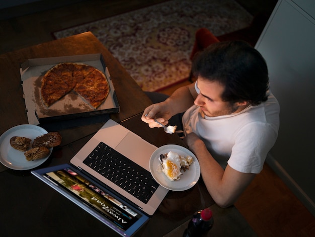 Free Photo top view man with snack and laptop