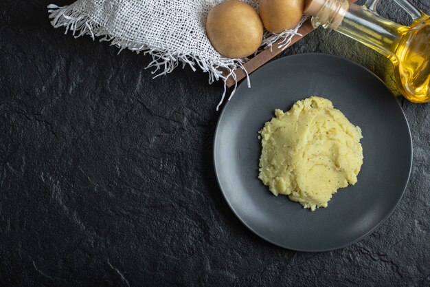 Free photo top view of mashed and fresh potato. mashed potato on black plate.