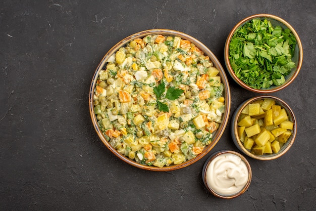 Top view of mayonnaise vegetable salad on dark surface