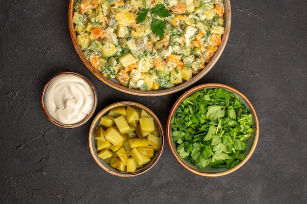 Top view of mayonnaise vegetable salad on dark surface