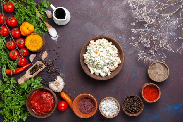 Top view mayyonaise salad with seasonings and vegetables on dark space