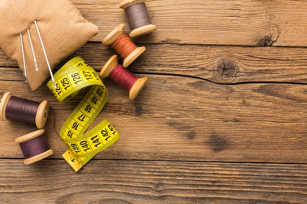 Top view of measuring tape with thread and needles