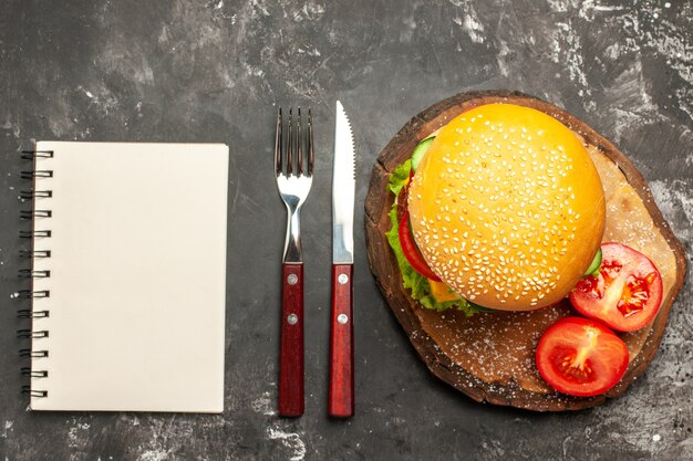 Top view meat burger with vegetables and cheese on dark desk bun fast-food sandwich