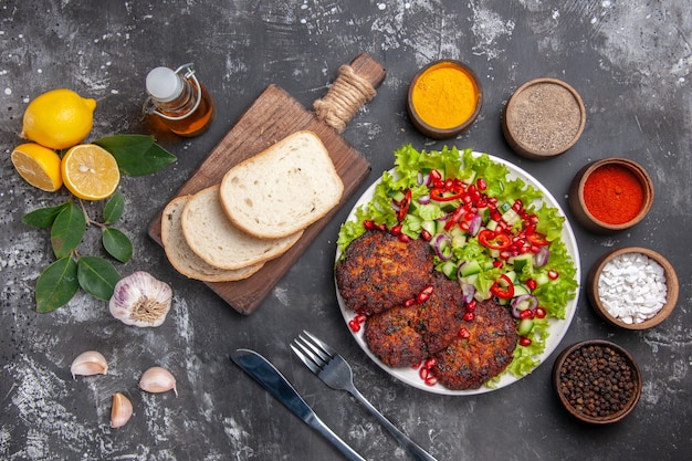 Free photo top view meat cutlets with salad and bread