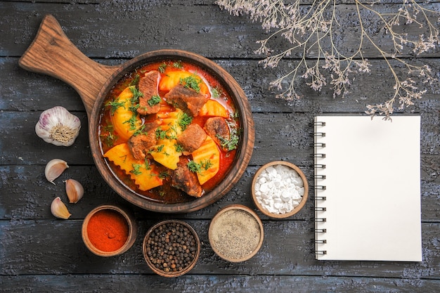 Free photo top view meat sauce soup with greens and potatoes on dark desk