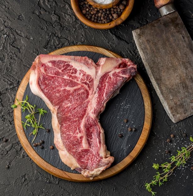 Top view of meat on slate with herbs and spices