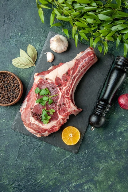 Free photo top view meat slice with pepper and salt on dark blue background color food meat kitchen animal chicken cow butcher