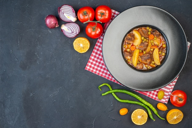 Free photo top view meat soup with garniture on round plate fresh vegetables on black table with free space