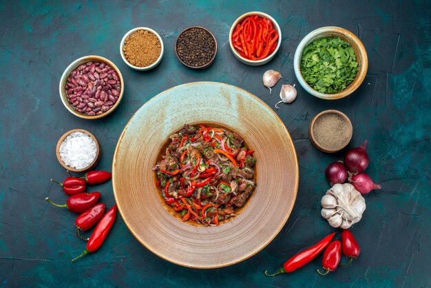 Top view meat vegetable salad sliced inside plate with greens seasonings on the dark-blue table salad food meal vegetable ingredient