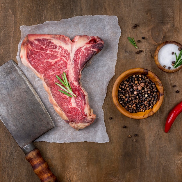 Top view of meat with cleaver and chili