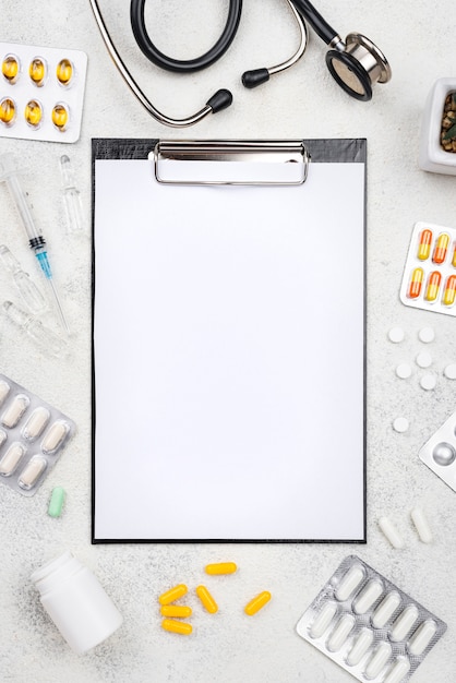 Top view medical desk composition with empty clipboard