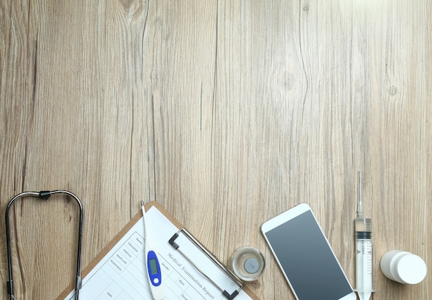 Free Photo top view of medical examination report,cellphone,and medical equipments on wooden desk