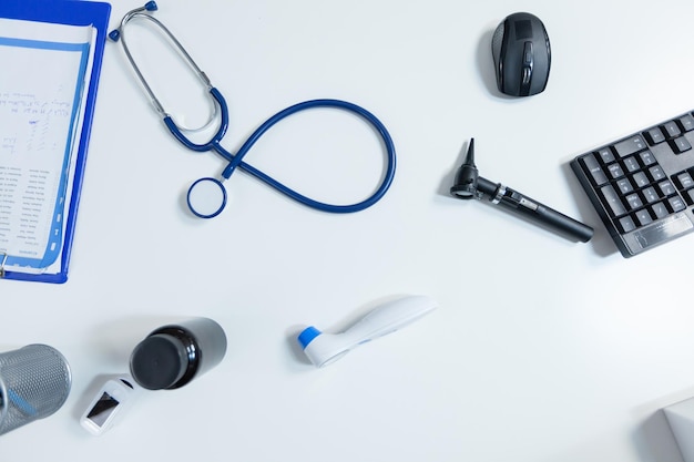 Top view of medical examination tools standing on table in empty modern doctor office ready for health care consultation. Hospital workplace equipped with professional instruments. Medicine support