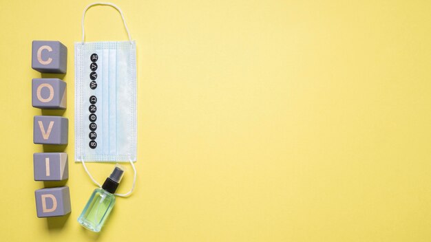 Top view of medical mask with wooden cubes saying covid