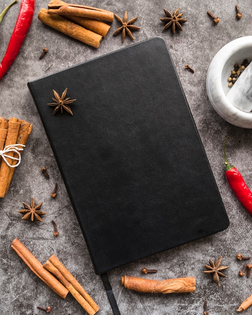 Free photo top view of menu book with cinnamon sticks and star anise