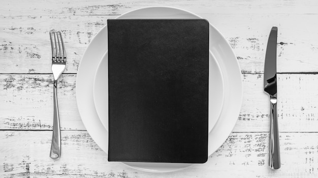 Free Photo top view of menu on plate with cutlery