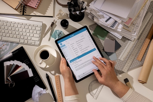 Free Photo top view of messy office workspace with tablet