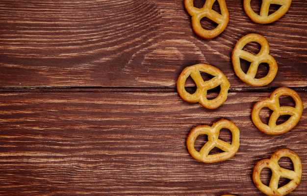 Free photo top view of mini pretzels on rustic wood with copy space