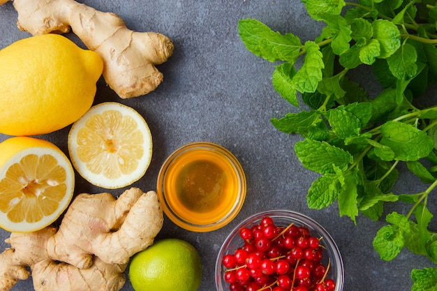 Free photo top view mint leaves with lemons, ginger, honey, redcurrant