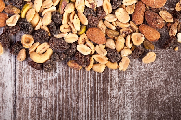 Over top view of Mix from healthy raw nuts on wooden background in studio photo. Healthy organic snack