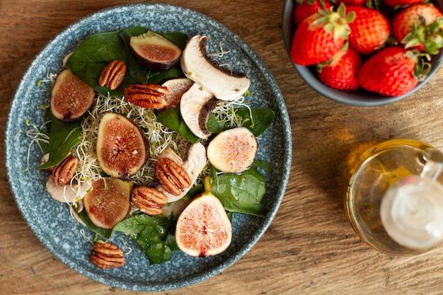 Free photo top view mix of nuts and figs on plate with strawberries