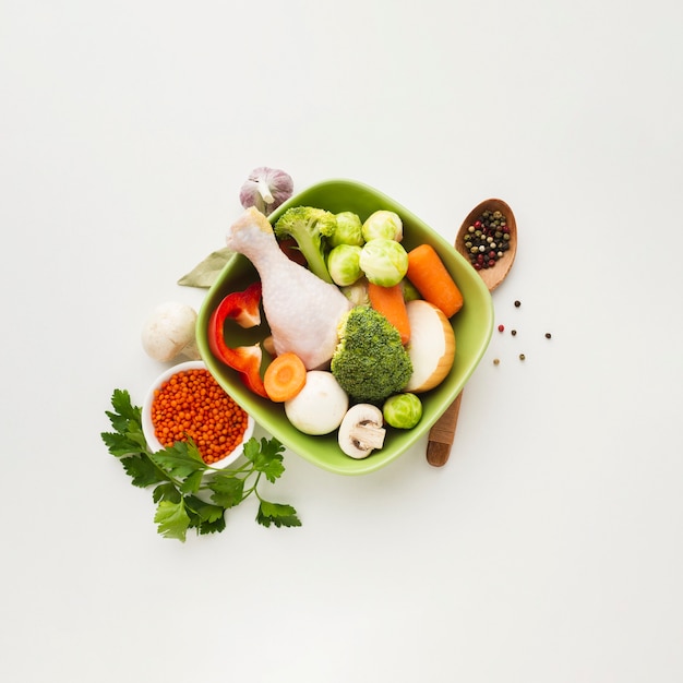 Free photo top view mix of vegetables in bowl with chicken drumstick