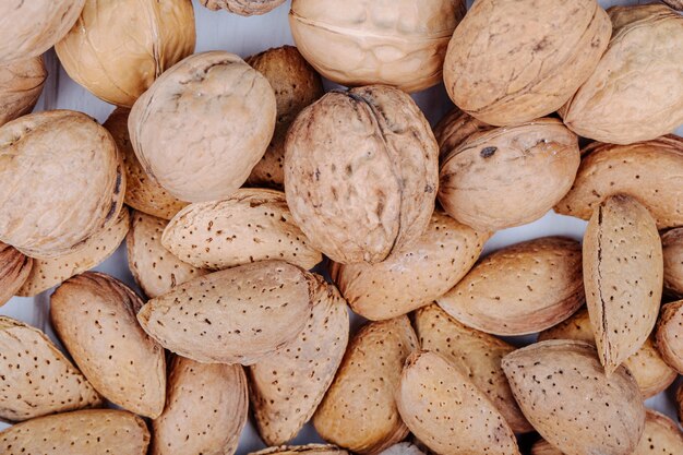 Top view of mixed nuts in shell walnuts and almond on white background