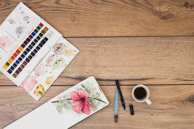 Top view of modern artist desk with watercolor equipment