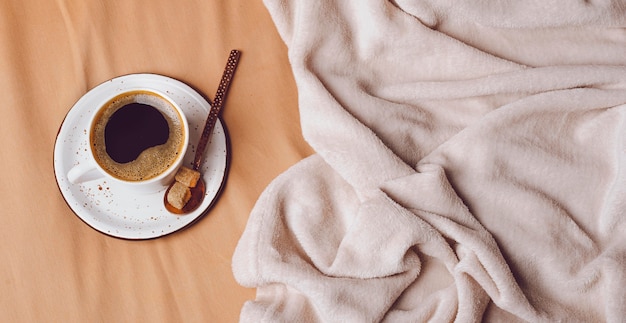 Free photo top view of morning coffee cup on bed with copy space