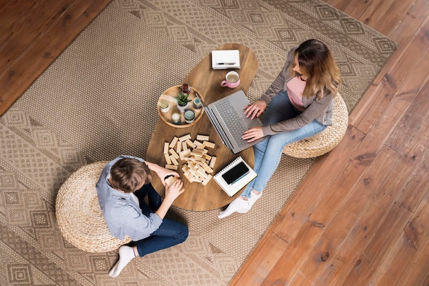 Top view mother working from home next to her son