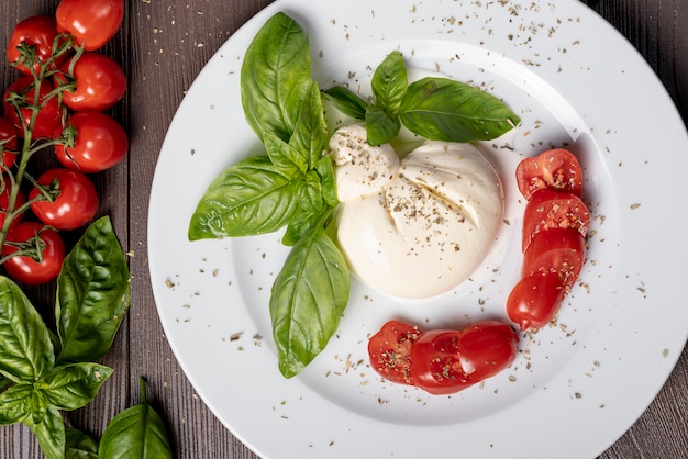 Free photo top view of mozzarella and cherry tomatoes on wooden table